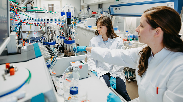 Zwei Wissenschaftlerinnen arbeiten in einem Labor an einem Miniplant, einen kleinen Reaktor (c) Jana Dünnhaupt Uni Magdeburg